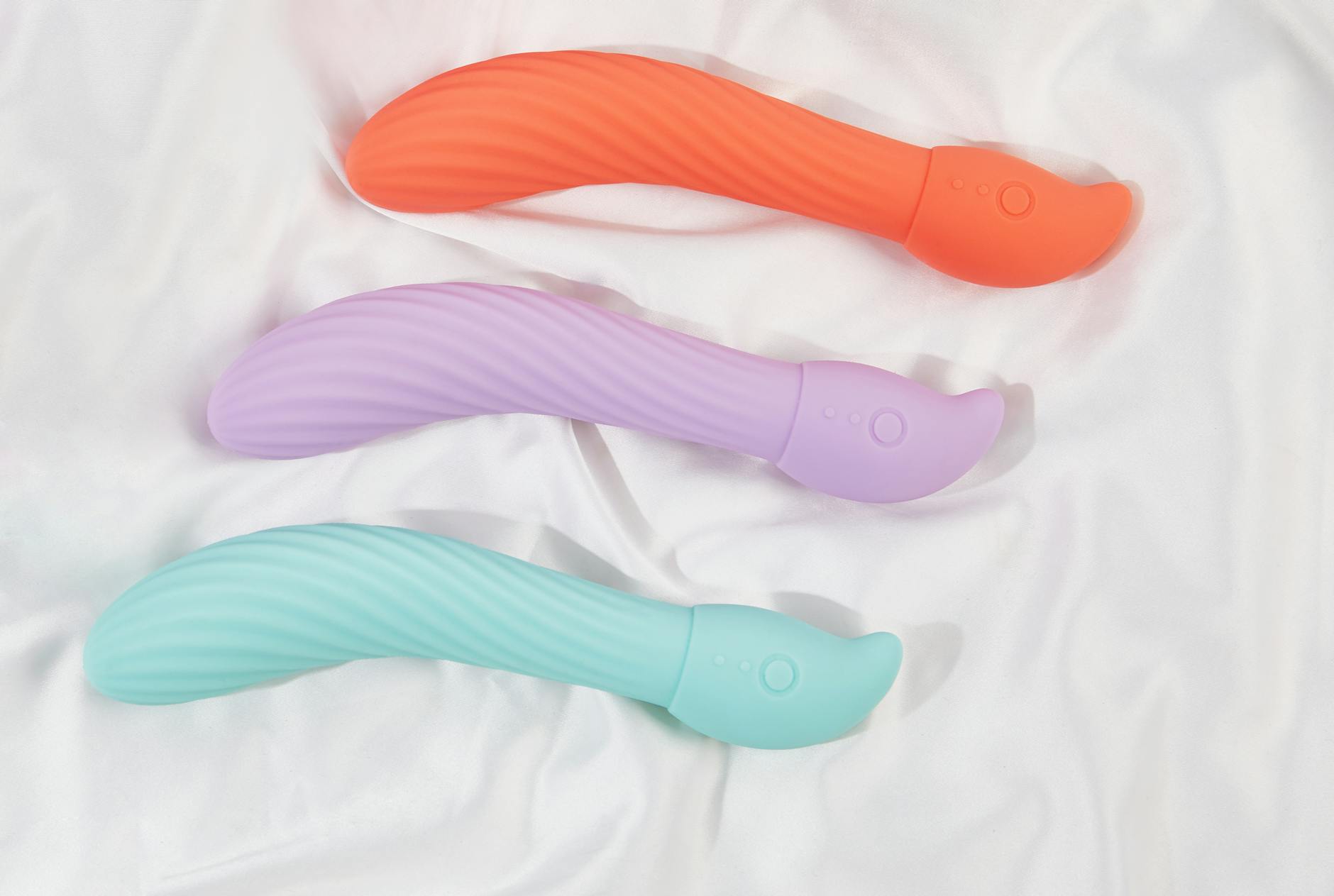 Mujer con gafas sosteniendo vibradores de silicona azul y rosa, con expresión pensativa
