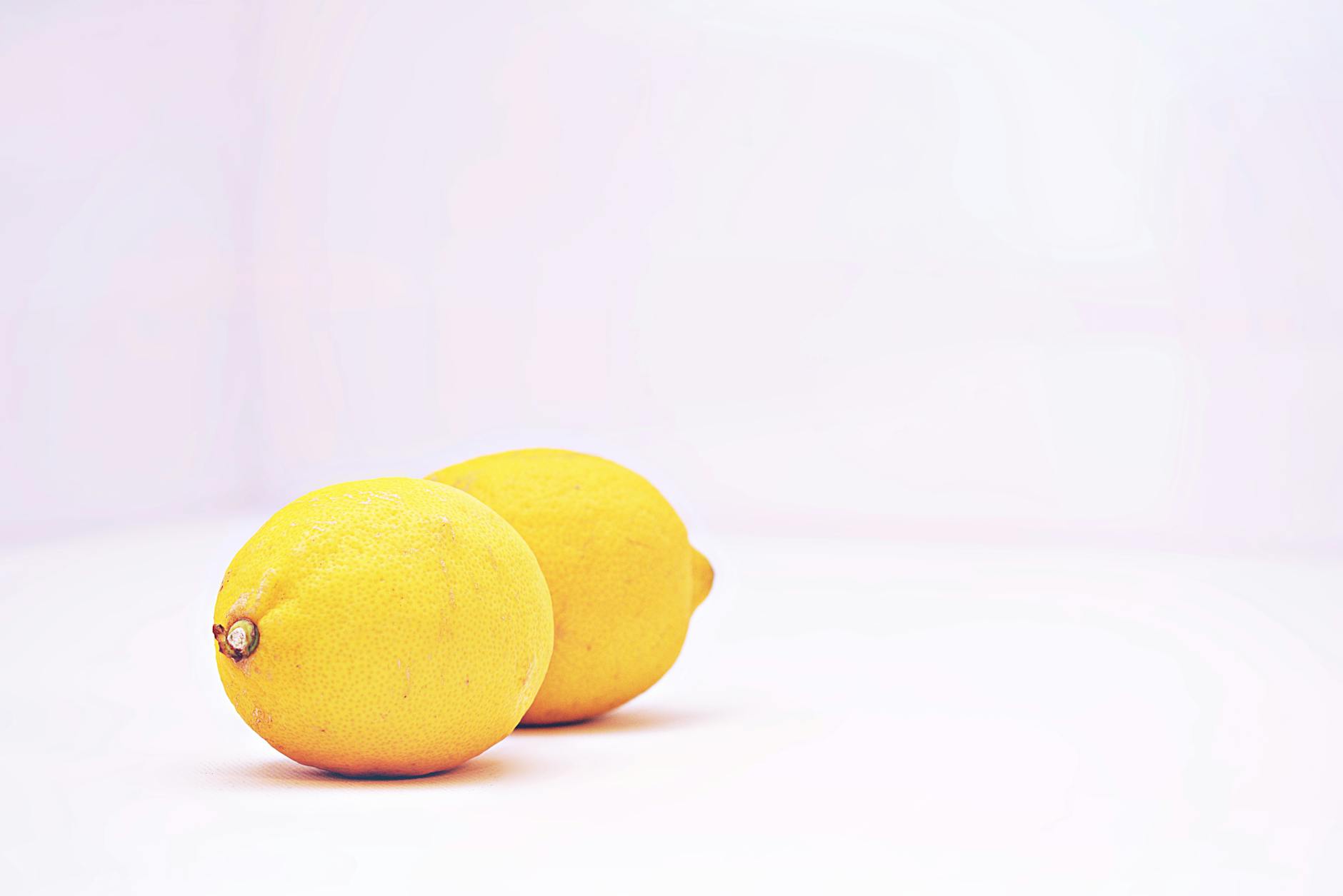 Limones vibrantes colocados contra un fondo blanco minimalista, simbolizando frescura y estimulación sensorial