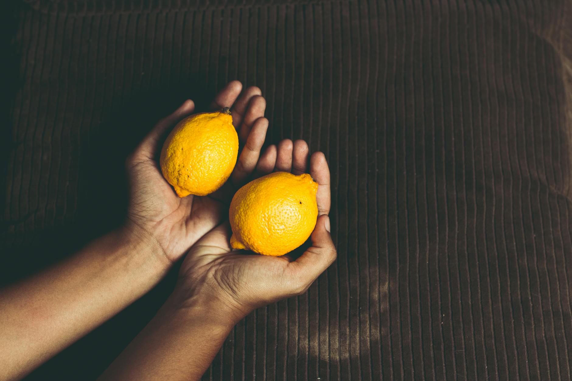 Limones frescos y brillantes en una composición plana sobre fondo pastel