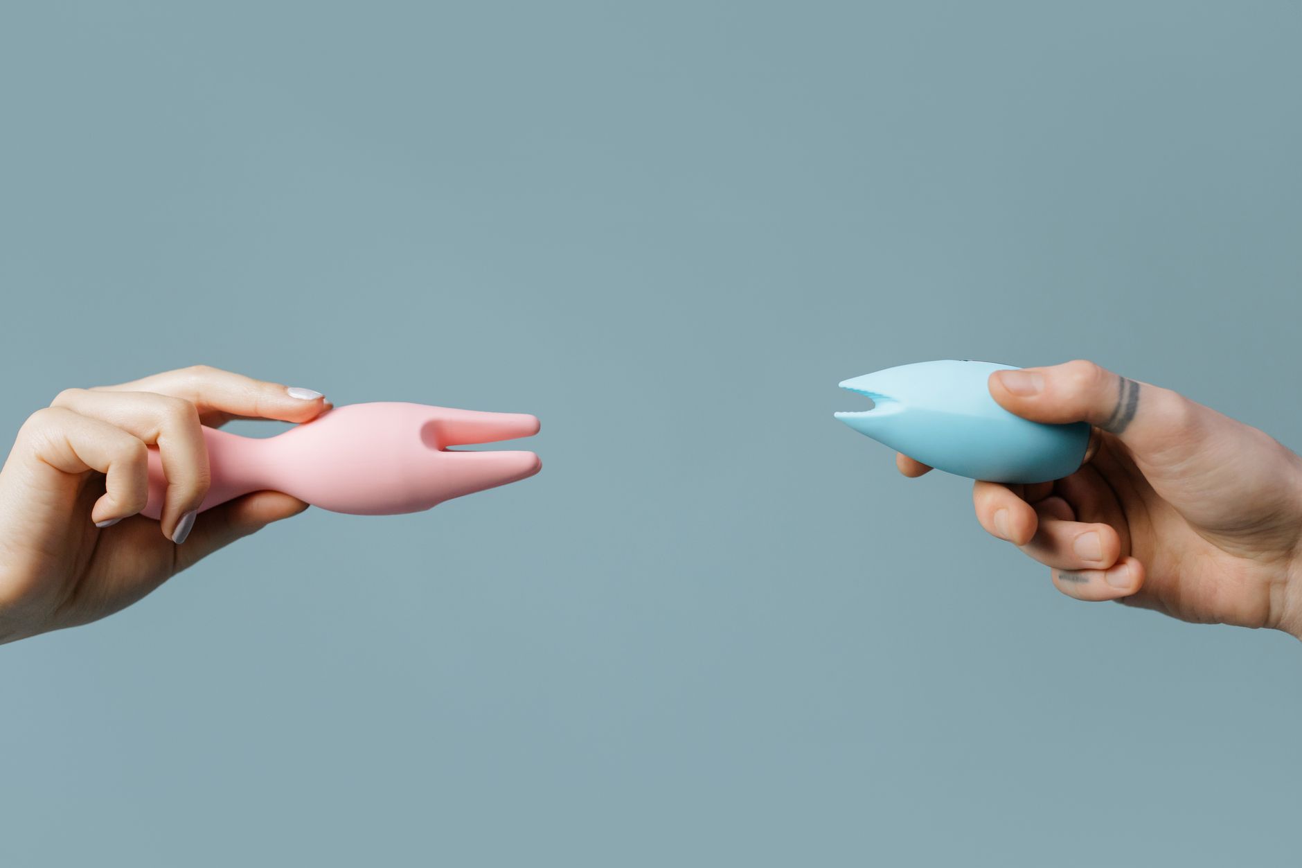 Vibrador de silicona azul sostenido en la mano contra un fondo púrpura, promoviendo el amor propio y la sexualidad
