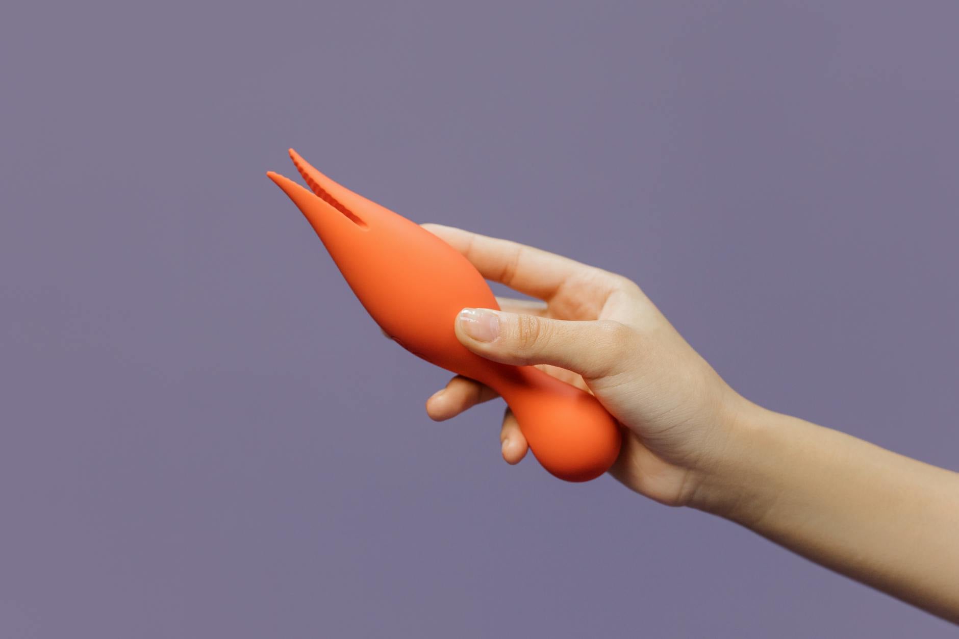 Mano sosteniendo un vibrador moderno contra un fondo minimalista, mostrando sensualidad contemporánea