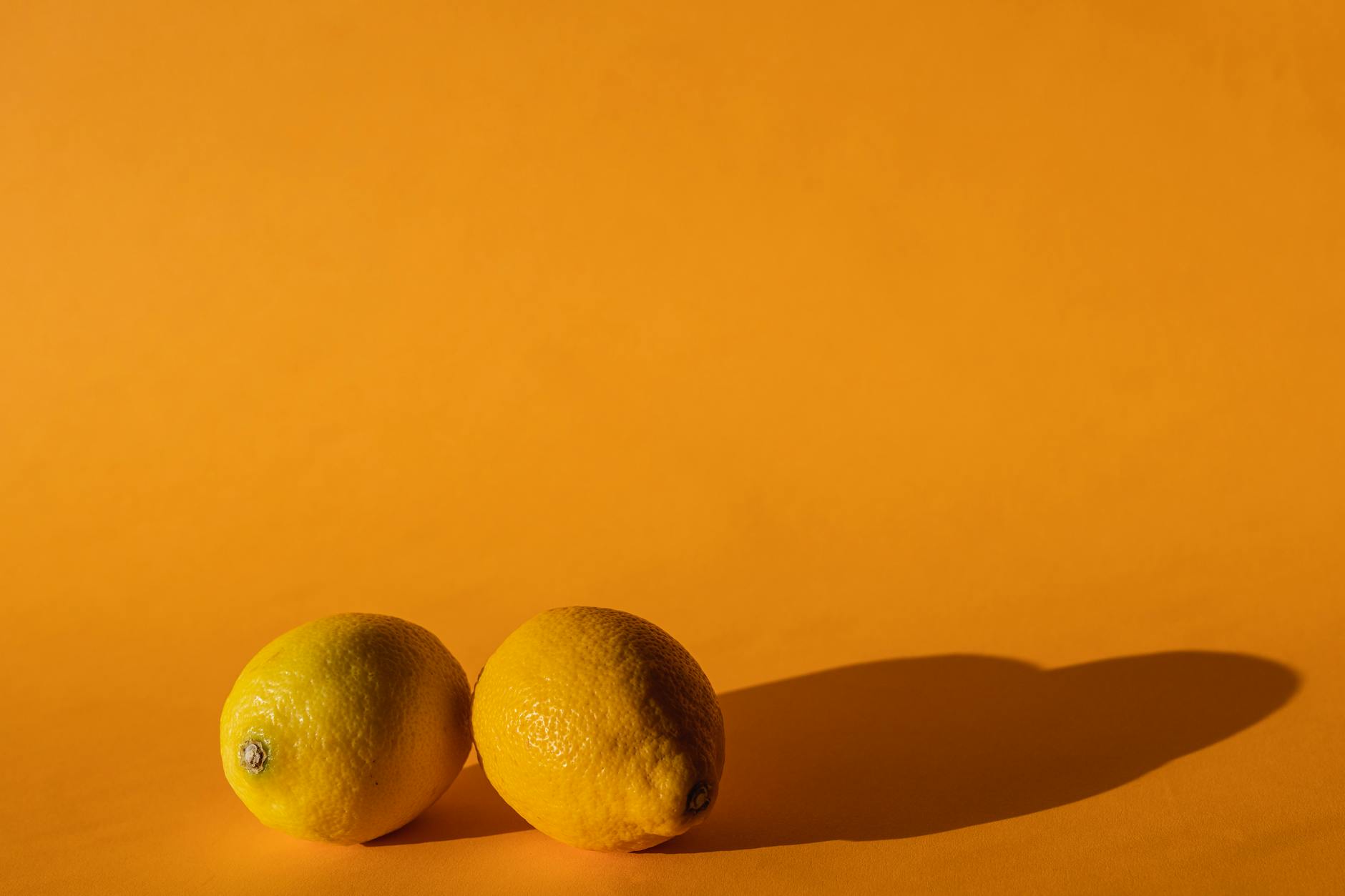 Limones vibrantes en una superficie amarilla brillante, representando cambios y renovación